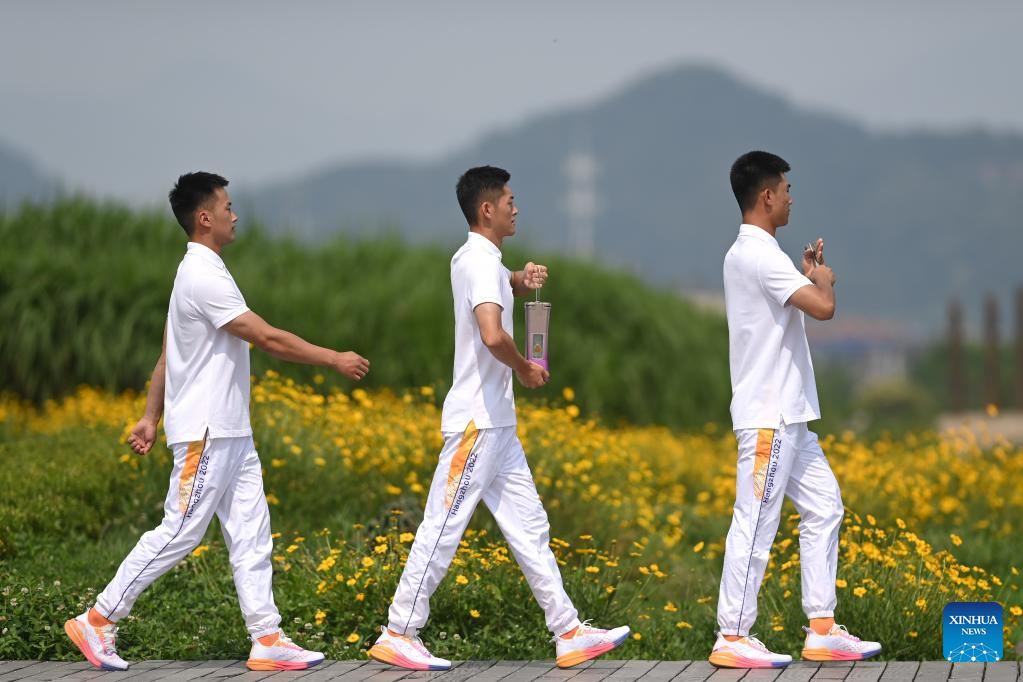 Flame guards leave with the flame lantern after the Hangzhou 2022 Asian Games Flame Lighting Ceremony at the Archaeological Ruins of Liangzhu City park in Hangzhou, east China's Zhejiang Province, June 15, 2023. /Xinhua