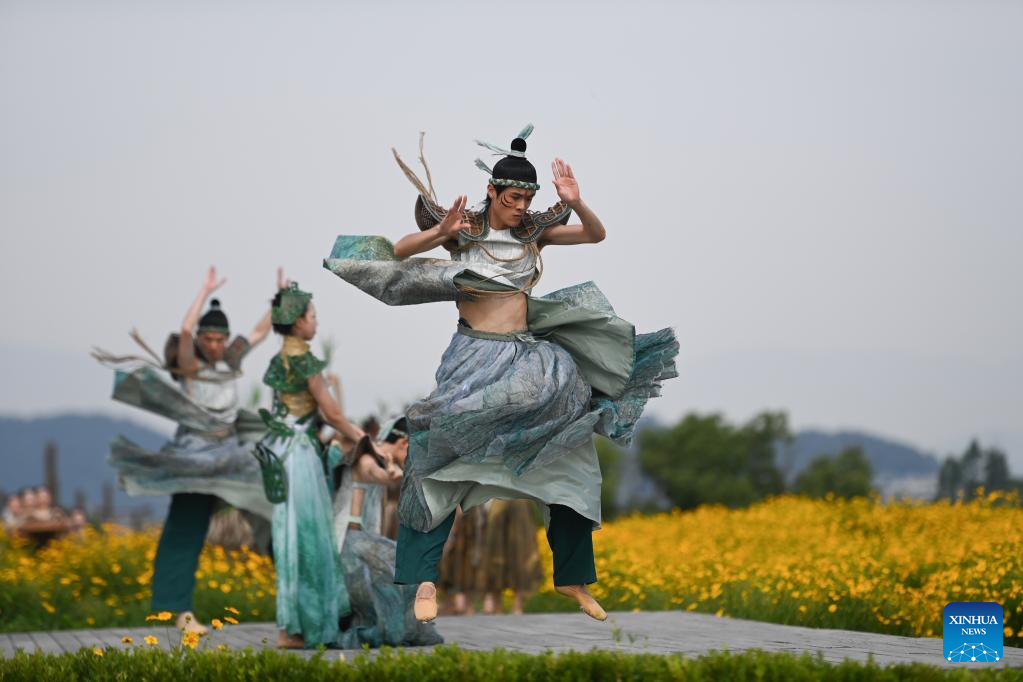 Dancers, playing roles of ancient Liangzhu villagers, perform during the Hangzhou 2022 Asian Games Flame Lighting Ceremony at the Archaeological Ruins of Liangzhu City park in Hangzhou, east China's Zhejiang Province, June 15, 2023. /Xinhua