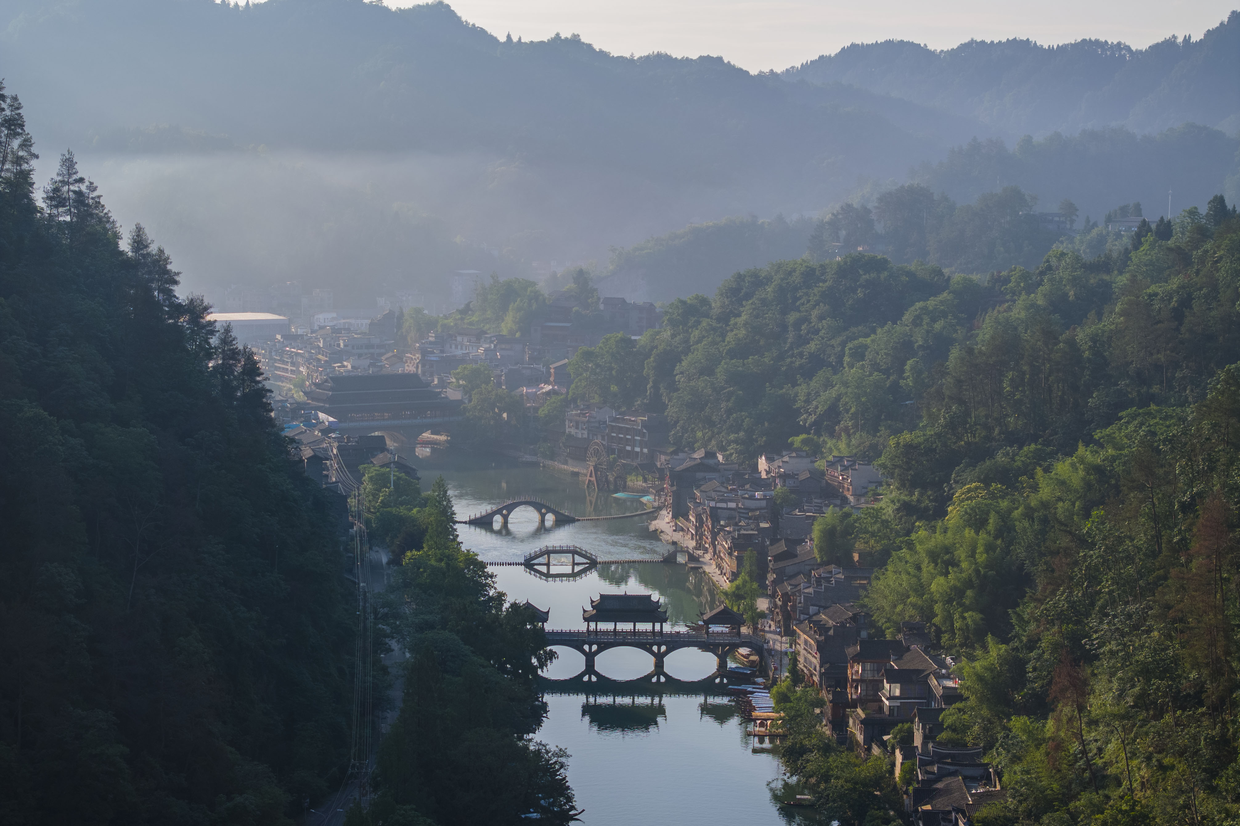 A photo shows traditional buildings and bridges in Fenghuang Ancient Town in Xiangxi, Hunan on May 29, 2023. /CNSPHOTO
