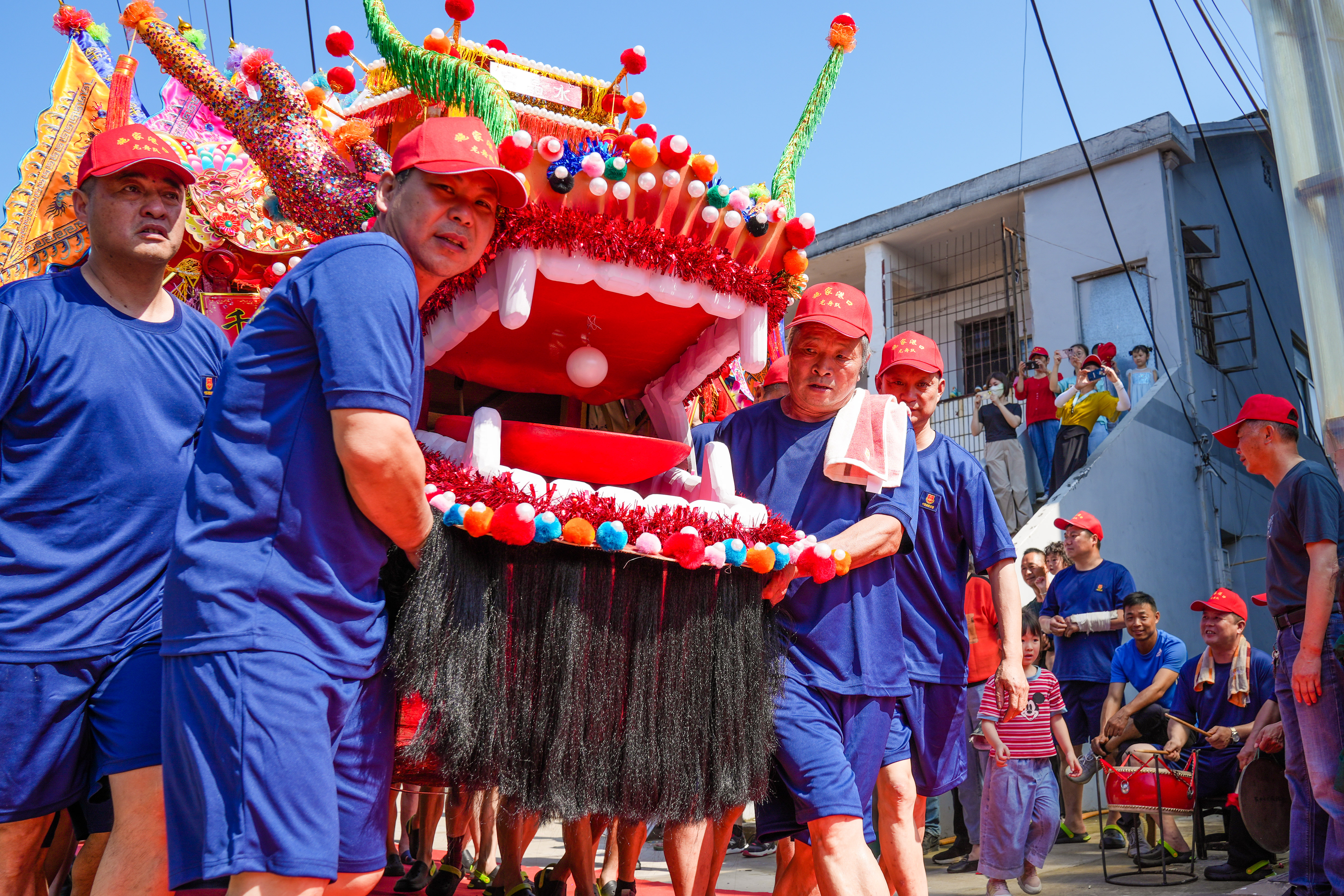 Villagers gather at the port to witness the event to set sail this specially decorated dragon boat. /CNSPHOTO