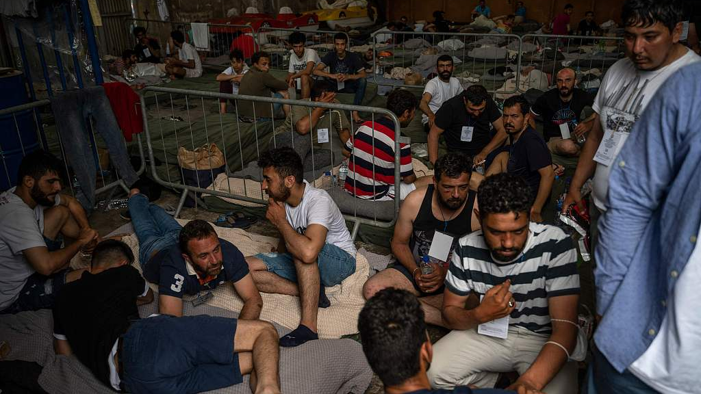 Survivors of a shipwreck sit inside a warehouse at the port in Kalamata town, Greece, June 15, 2023. /CFP