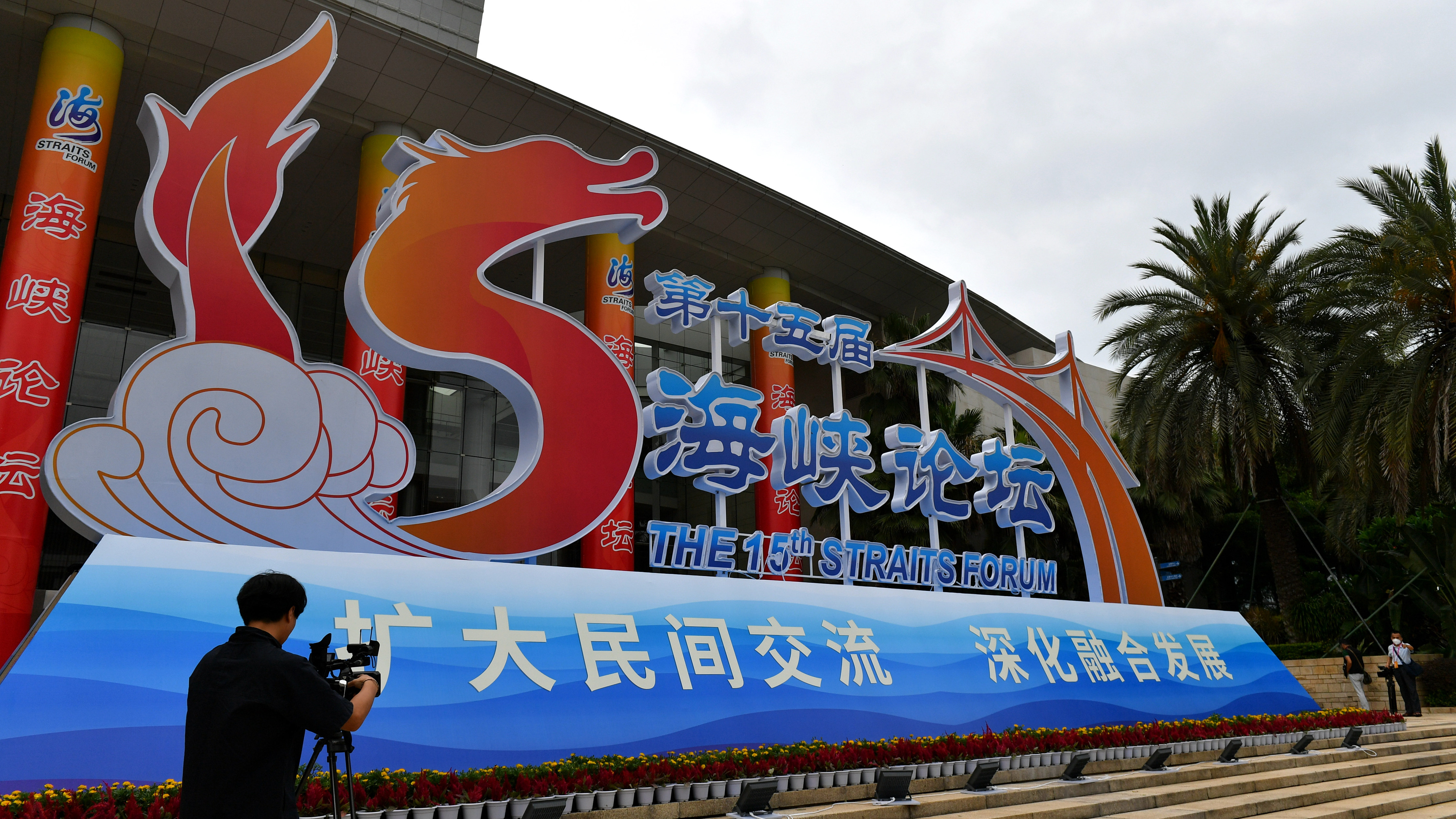 A journalist takes photos in front of the main venue of the Straits Forum in Xiamen, east China's Fujian Province, June 15, 2023. /CFP