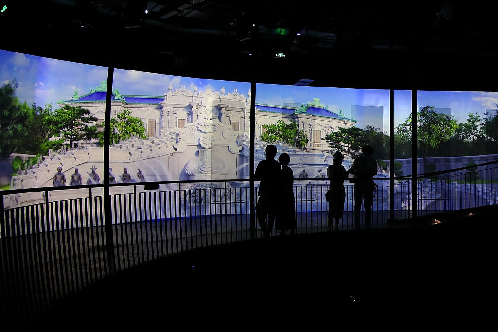 Tourists watch a screen that digitally recreates the Old Summer Palace during an exhibition in Shougang Industrial Heritage Park in Beijing, capital of China, July 12, 2020. /CFP