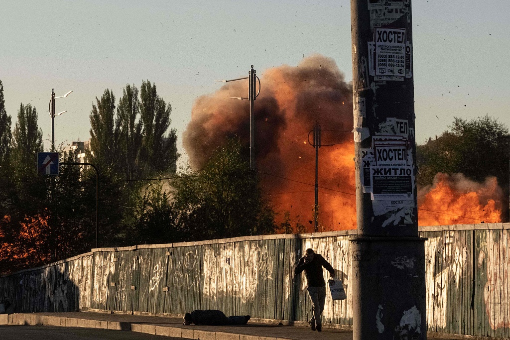 Smoke rises as a man runs along the street after a drone attack in Kyiv, Russia, October 17, 2022. /CFP