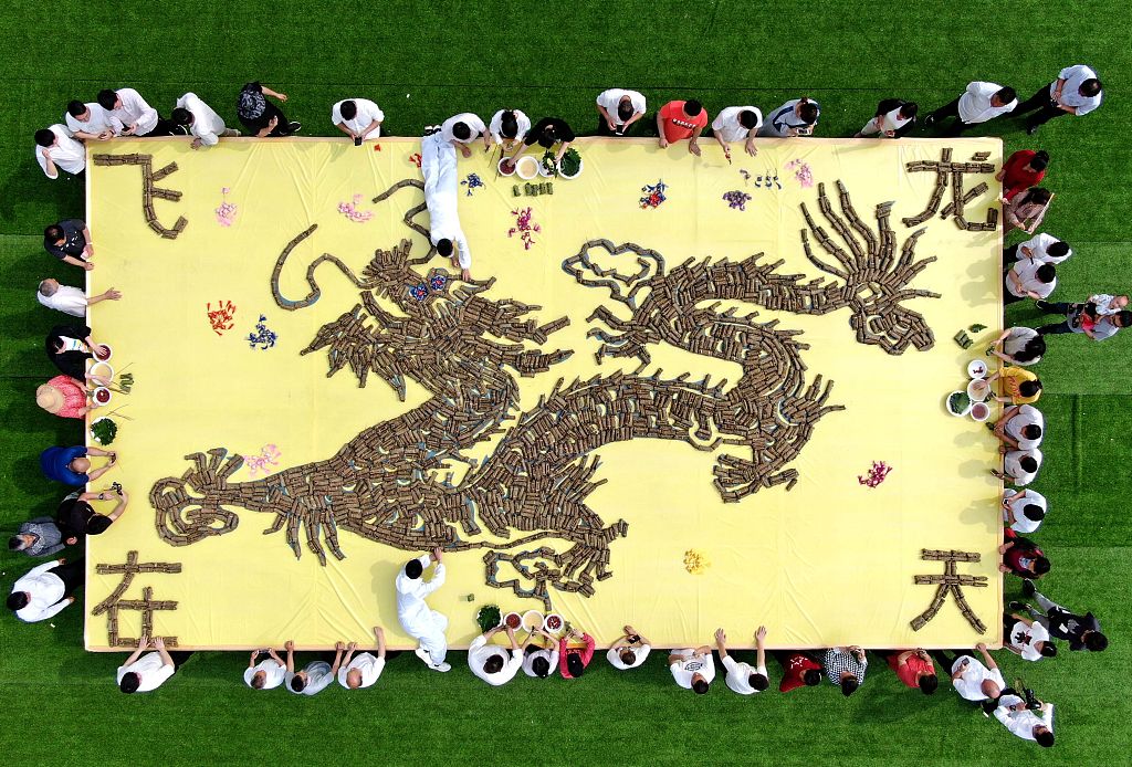 A huge image of a flying dragon made from tens of thousands of glutinous millet dumplings wrapped in quercus dentate tree leaves is seen at Laojun Mountain, Henan Province, June 6, 2019. /CFP