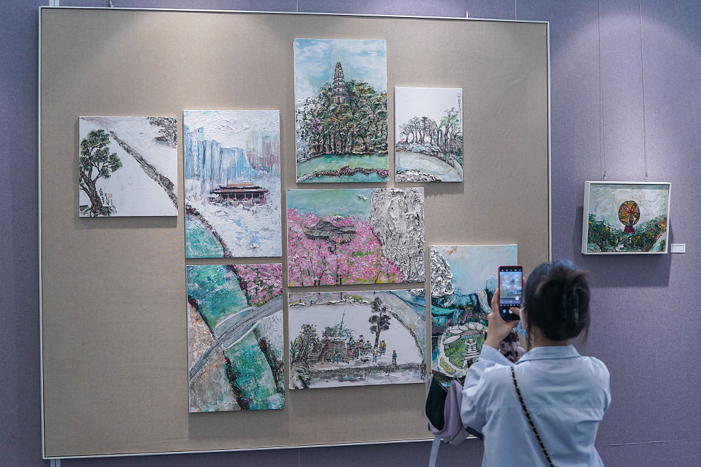 A visitor appreciates artworks exhibited at the Sino-German Arts Exchange Exhibition in Nanning, Guangxi Zhuang Autonomous Region, China, May 19, 2023. /CFP