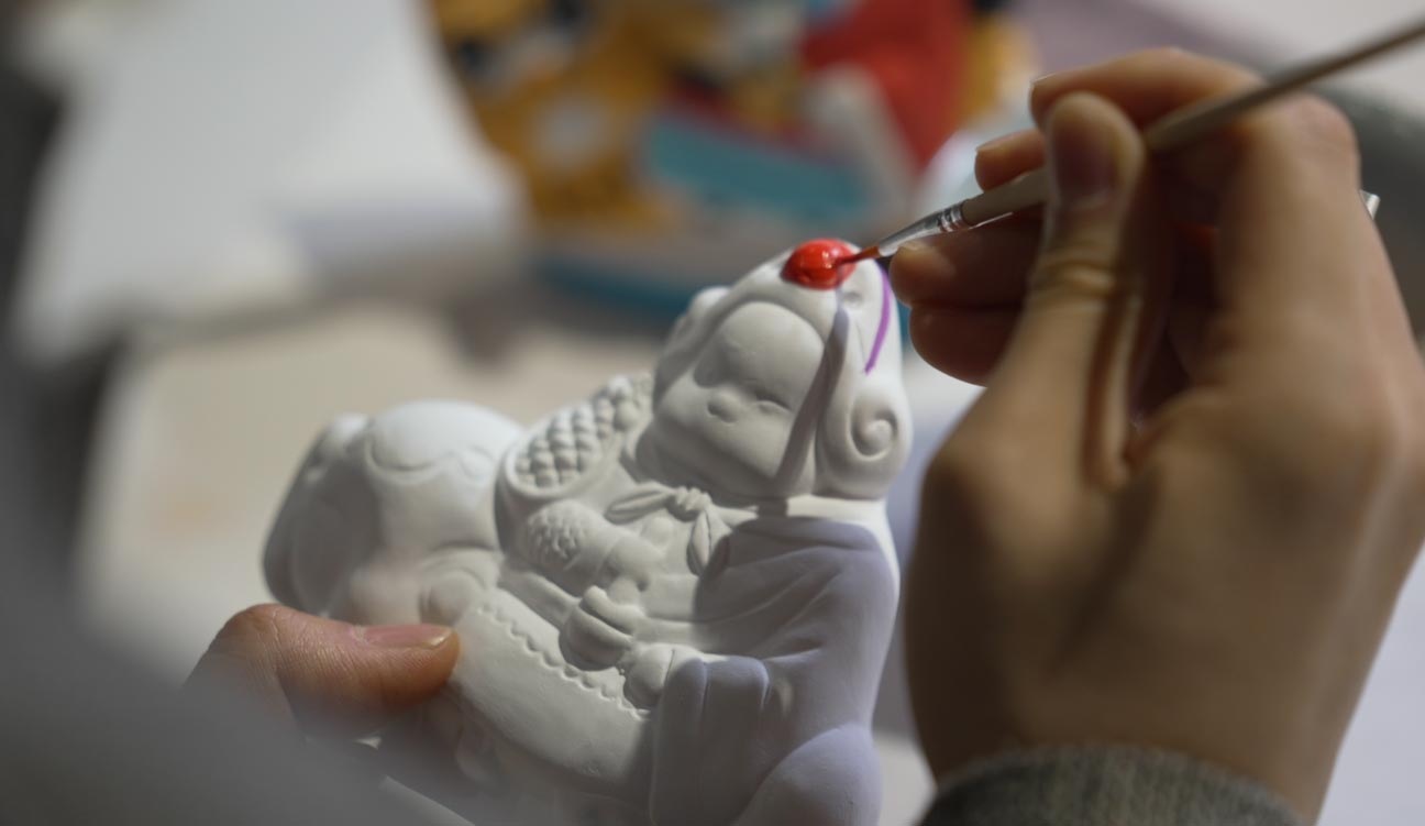 Julian Waghann learns to paint a Lord Rabbit figurine at a DIY handicraft workshop in the Cao Xueqin Memorial Hall Museum in downtown Beijing, in May 2023. /CGTN