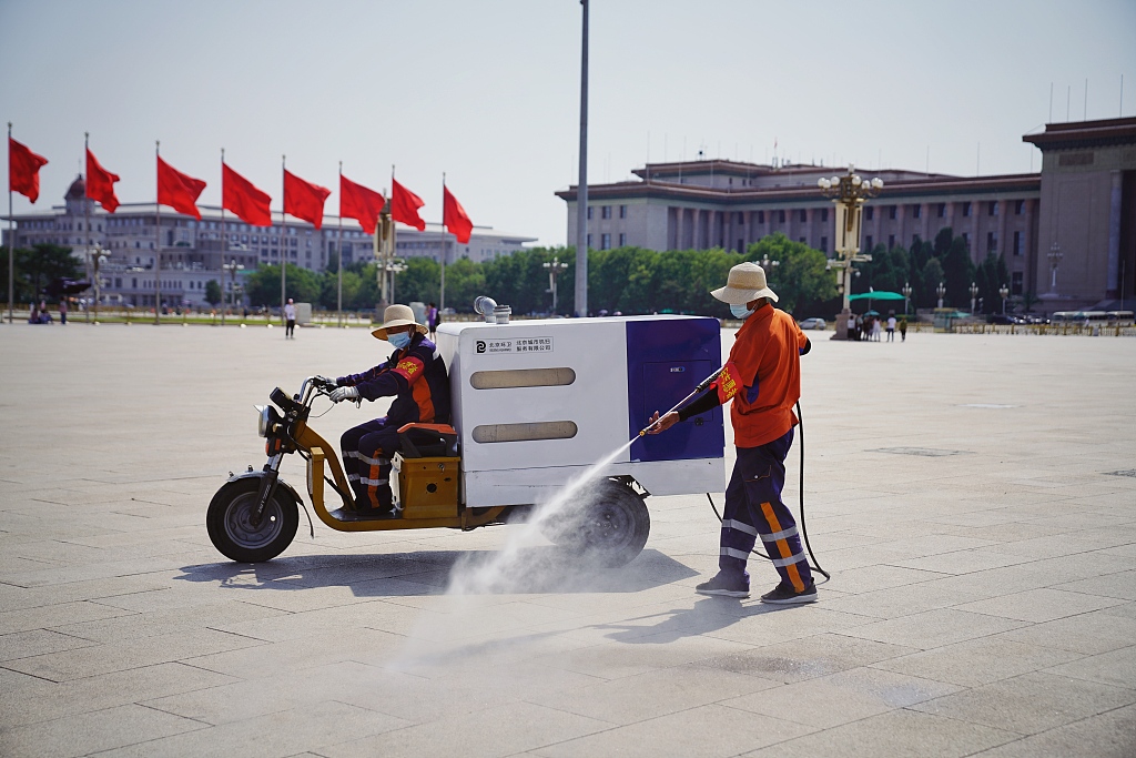 Street cleaners cleaning a square in Beijing amid the heat wave. /CFP