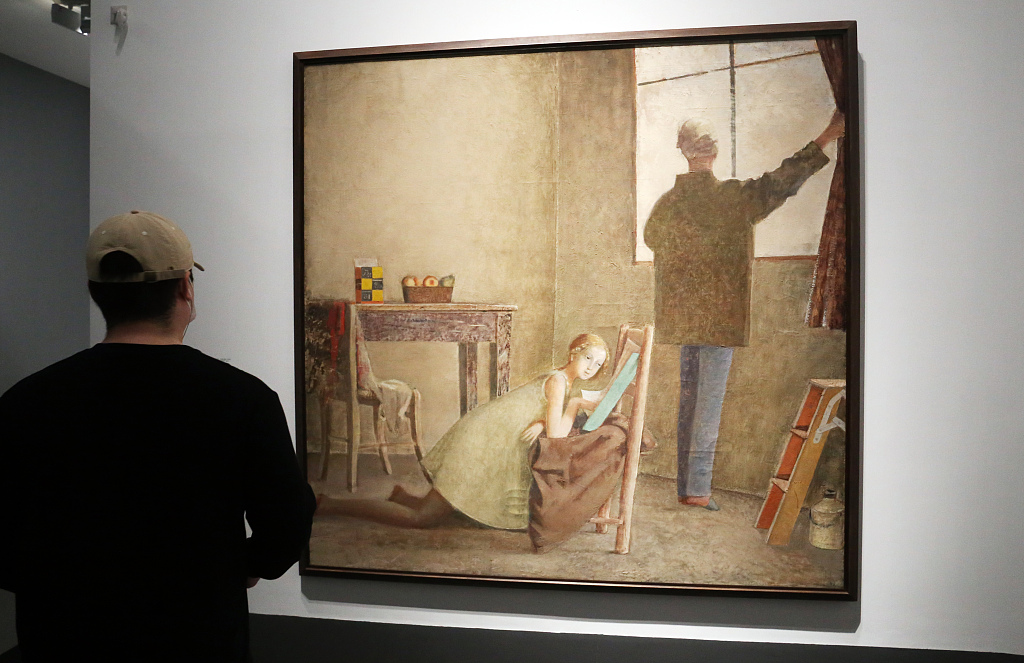 A visitor views a painting at the 