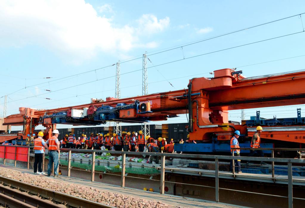 Construction workers operate the Taihang machine to replace a worn-out bridge section on the Shuohuang railway line in north China's Hebei Province, June 20, 2023. /CMG