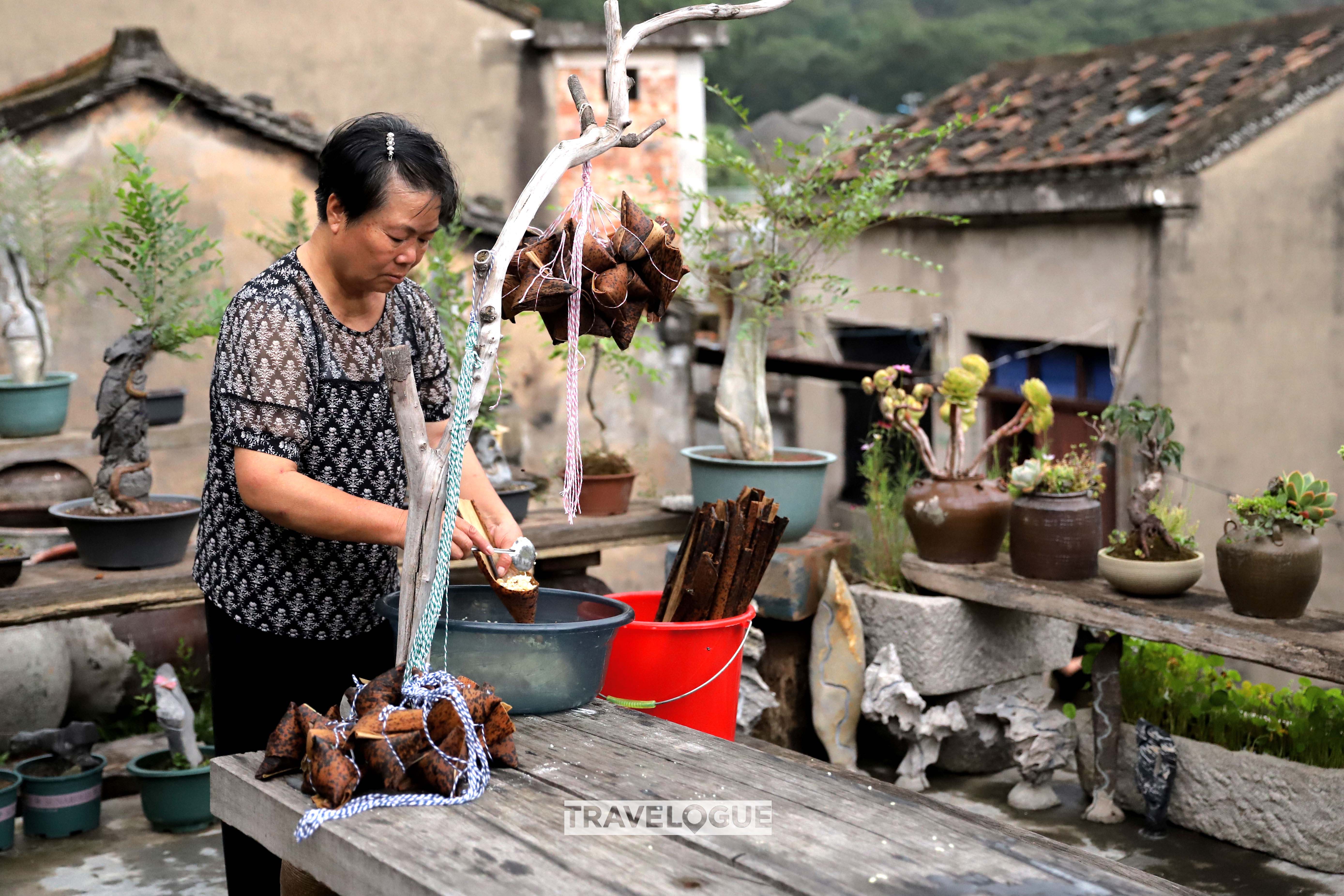A woman makes zongzi in Fuding, Fujian Province. /CGTN