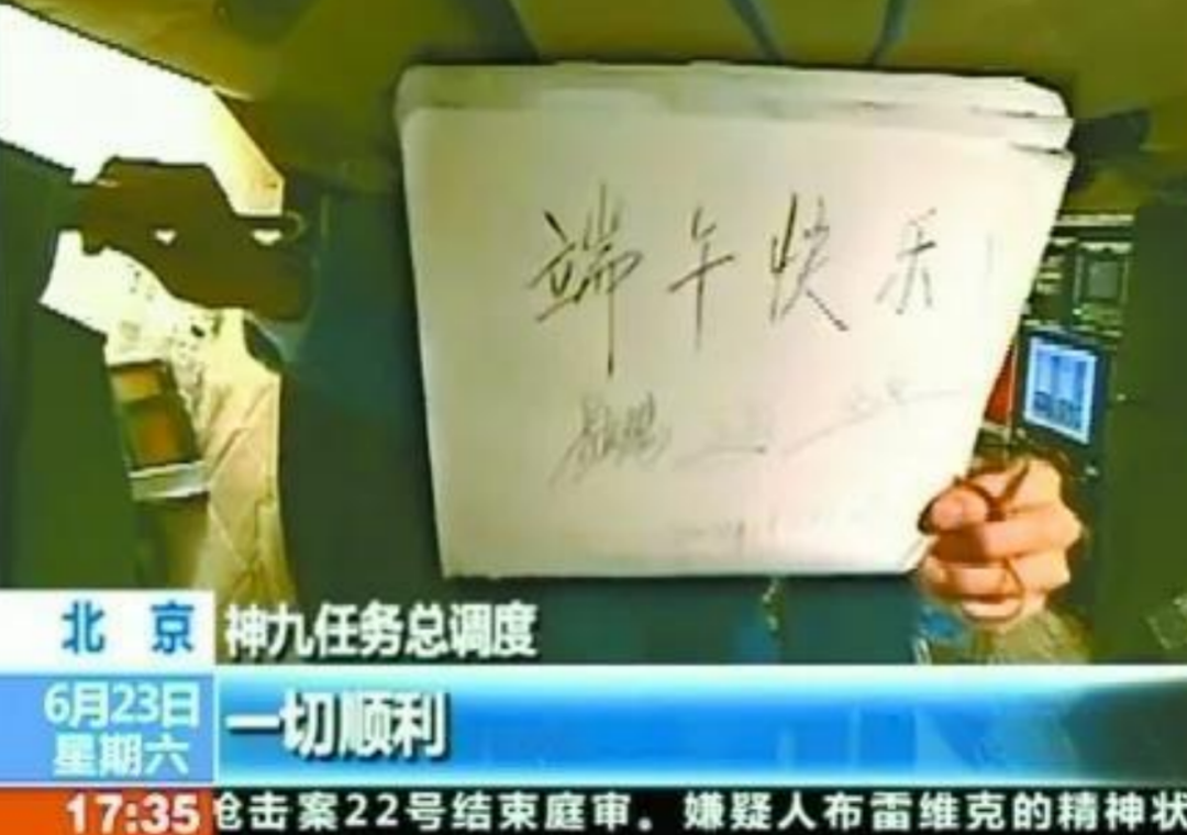 China's Shenzhou-9 crew holds a board reading 