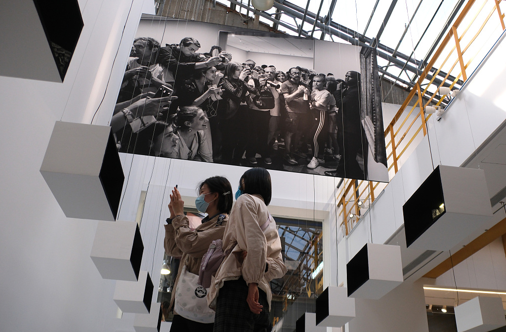 Visitors look at photos by French photographer Gerard Uferas exhibited at the 1905 Cultural and Creative Park in Shenyang, Liaoning, April 30, 2023. /CFP