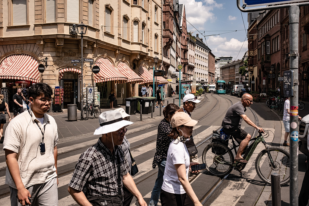 Pedestrians cross a road during hot weather in Frankfurt, Germany, June 20, 2023. /CFP
