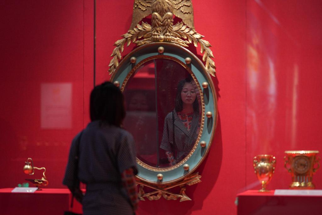 A visitor views a mirror used by French emperor Napoleon Bonaparte at an exhibition titled 