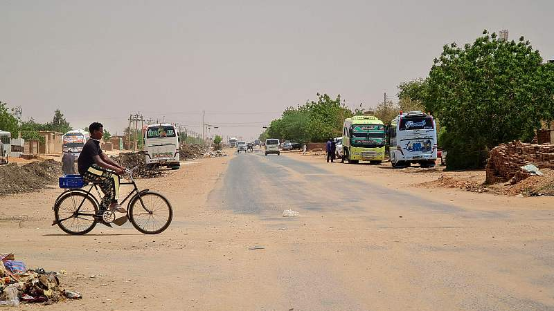 A boy crosses an empty road on his bicycle in southern Khartoum, Sudan, June 21, 2023. /CFP