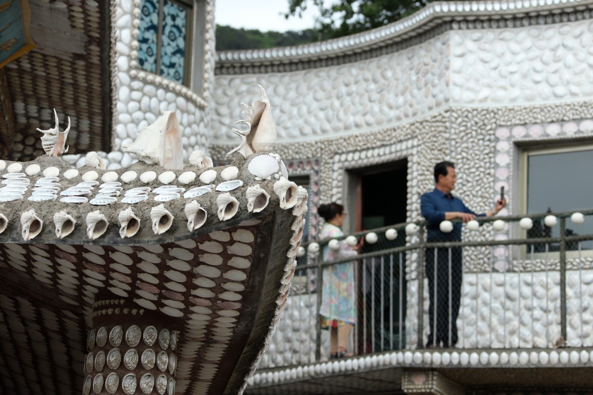 Tourists visit a traditional Chinese house decorated with seashells in Lingshan Island of east China's Shandong Province, May 24, 2023. /CNSPHOTO