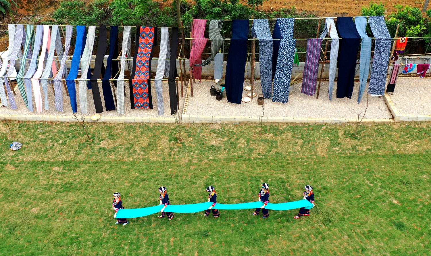 Yao people hang dyed clothes in Hechi of south China's Guangxi Zhuang Autonomous Region, on April 23, 2023. /CNSPHOTO