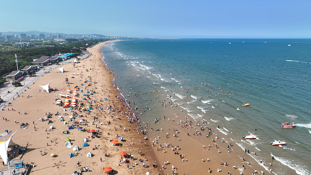 Vacationers on a beach in east China's Shandong Province, June 24, 2023. /CFP
