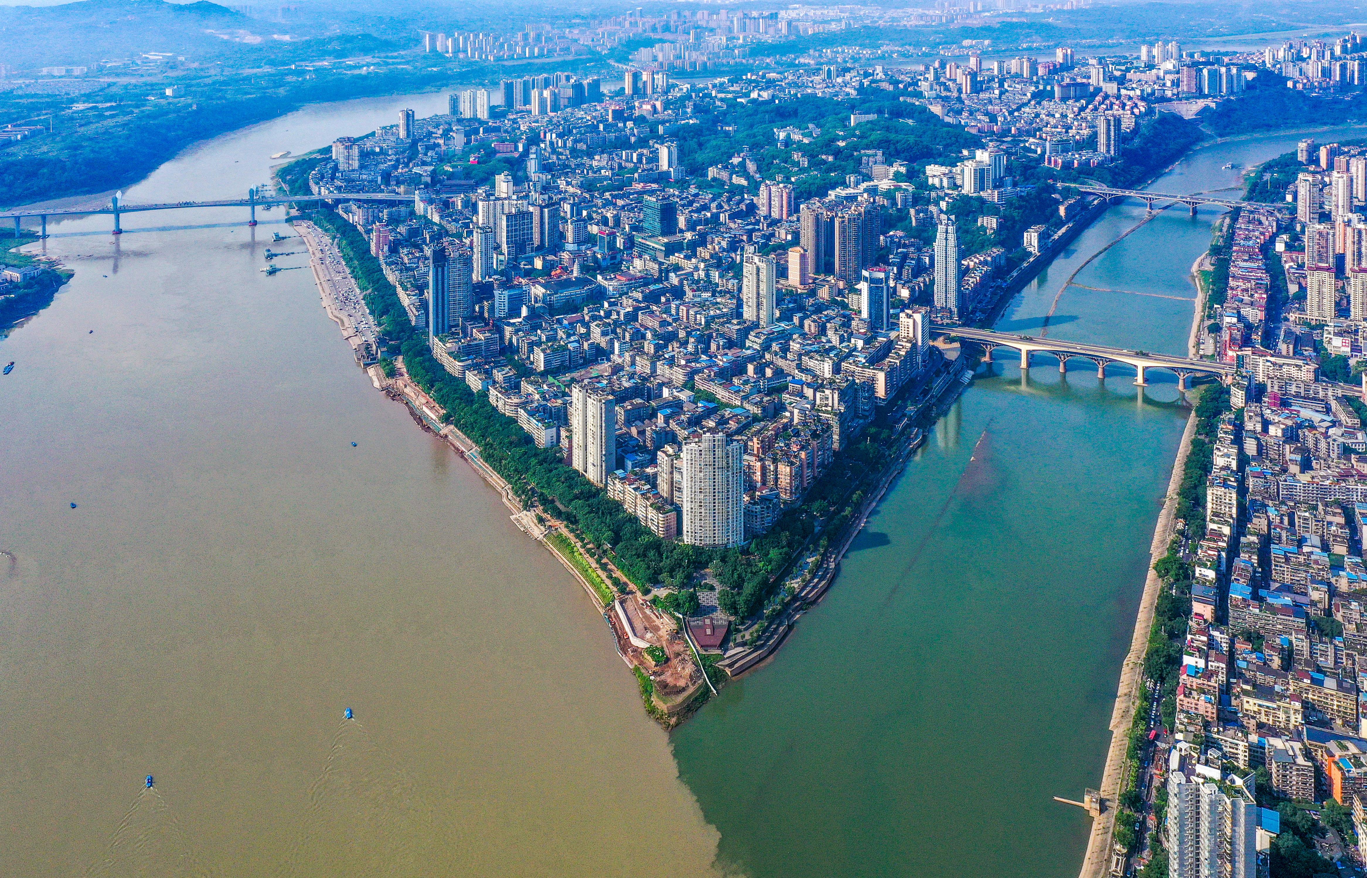 Photo taken on June 6, 2023, shows the phenomenon at the confluence of the Yangtze River and the Tuojiang River. The color differences are mainly due to their difference in debris and vegetation, causing a contrasting scene when the two bodies of water merge into one another to become a single river. /CNSPHOTO