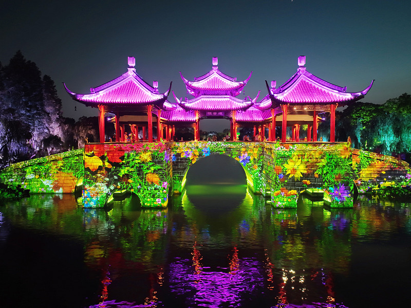 Colorful lights illuminate the ancient bridge at the Slender West Lake scenic area in Yangzhou City, Jiangsu Province, June 26, 2023. /CFP