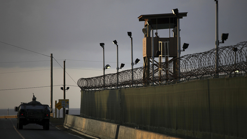 In this March 30, 2010 photo reviewed by the U.S. military, a U.S. trooper stands in the turret of a vehicle with a machine gun, left, as a guard looks out from a tower at the detention facility on Guantanamo Bay U.S. Naval Base in Cuba. /CFP