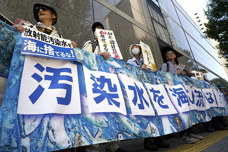 Protesters hold a banner that reads, 