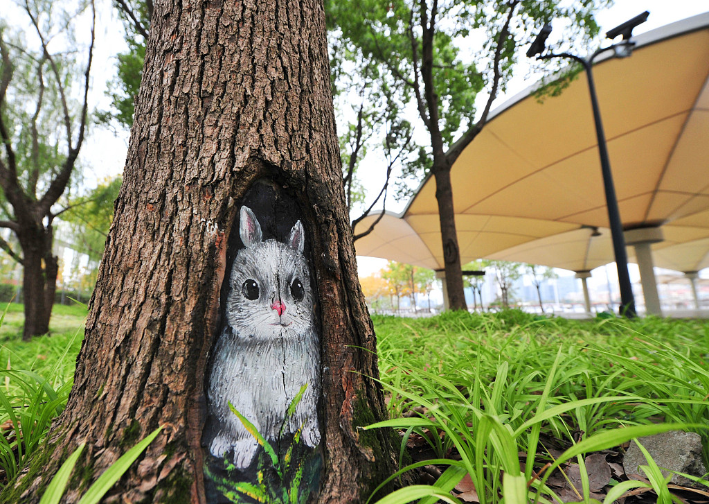 A photo shows a painting daubed on a tree trunk. /CFP