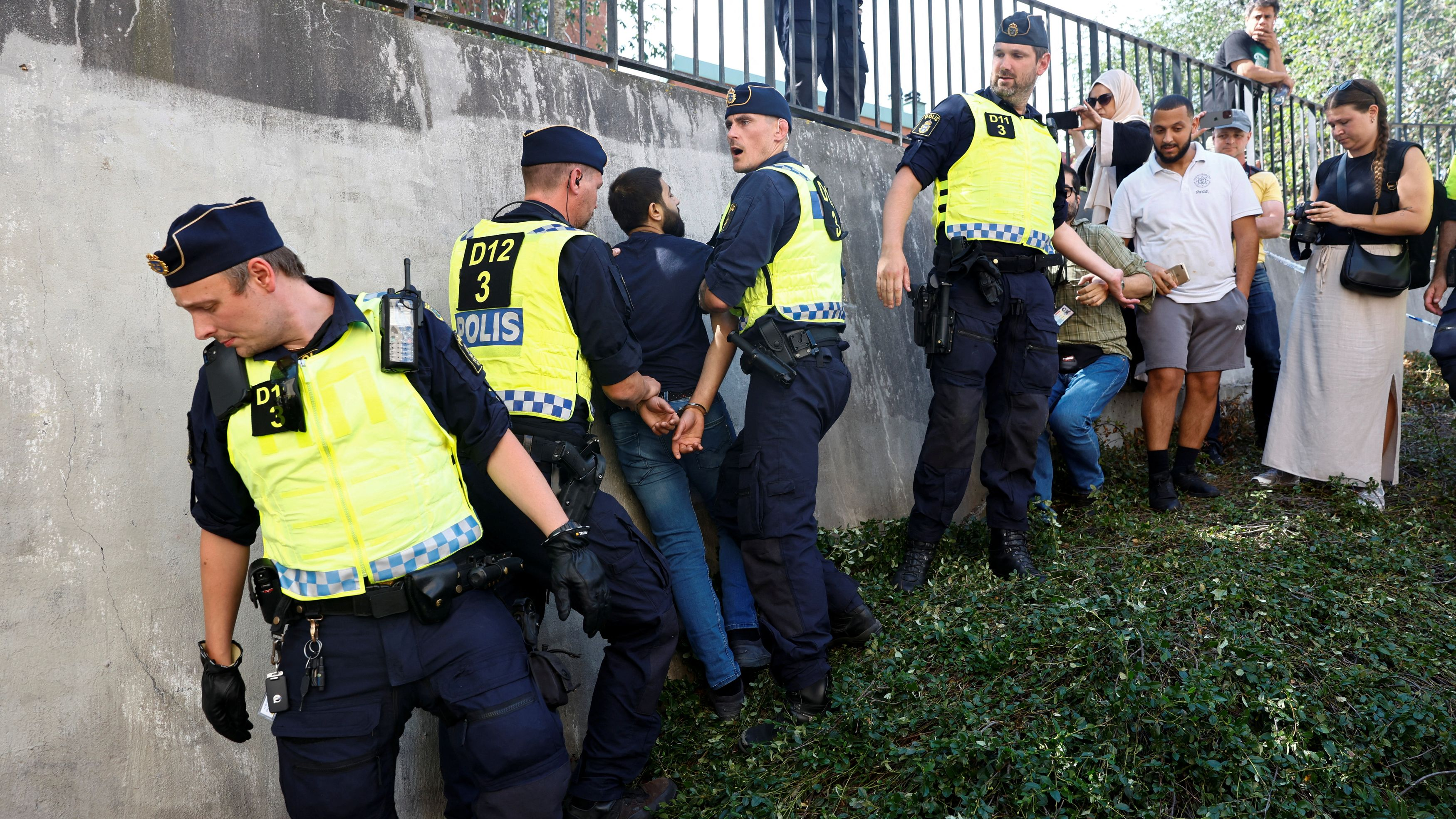 Police officers intervene after people's reaction as demonstrators burn the Quran (not pictured) outside Stockholm's central mosque in Stockholm, Sweden June 28, 2023. /Reuters