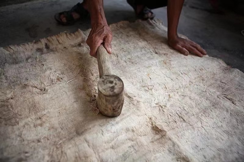A photo shows the process of making tree bark cloth. /Photo provided to CGTN