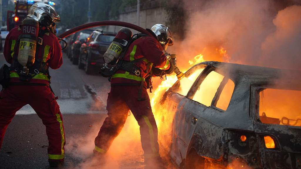 Firefighters extinguish a burning vehicle destroyed by protesters in Nanterre, west of Paris, France, June 27, 2023. /CFP