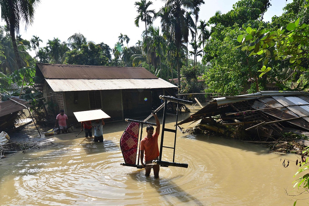 People remove furniture from their house in a flooded area following monsoon rains in Kenduguri village of Bajali district, Assam, India, June 23, 2023. /CFP