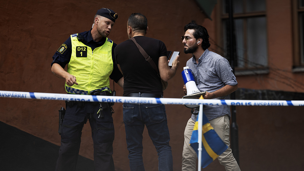 A security talks to men at the Stockholm Mosque in Stockholm, Sweden, June 28, 2023. /CFP