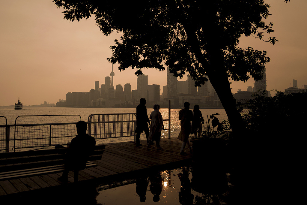 People watch the sunset as the smoke from wildfires drifts into Toronto on June 28, 2023. /CFP