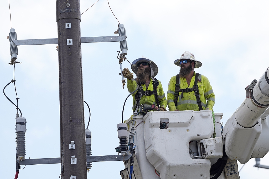 Workers repair a power line in Houston, Texas, USA, June 29, 2023. An unrelenting heatwave in Texas is testing the state's power grid as demand soars during a second week of triple-digit Fahrenheit temperatures. /VCG
