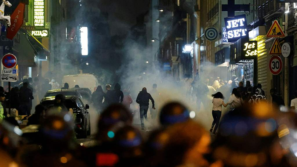 Demonstrators run as French police officers use tear gas in Paris on July 2, 2023, five days after a 17-year-old man was killed by police in Nanterre, a western suburb of Paris. /CFP