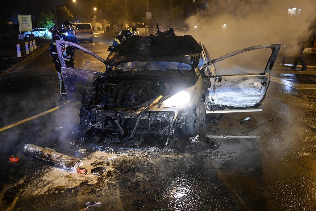 Firefighters extinguish a car that caught fire in Nantes, western France on early July 1, 2023. /CFP