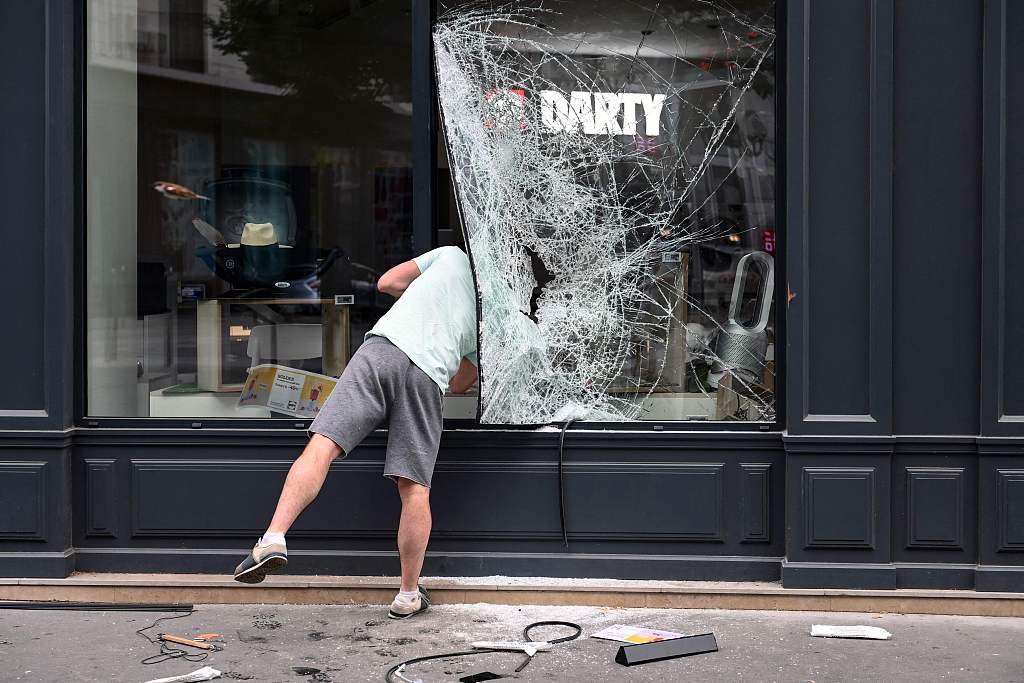 A pedestrian looks into a looted shop in Lyon, southeastern France, July 1, 2023. /CFP