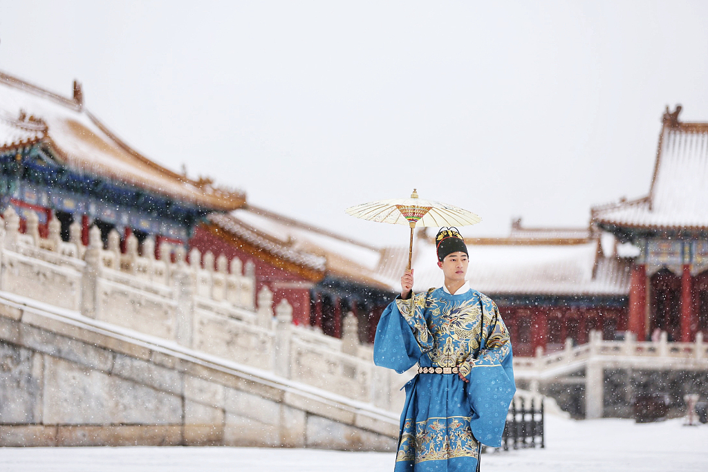 A visitor dressed in traditional Chinese costume poses for a photo at the Palace Museum in Beijing, November 7, 2021. /CFP