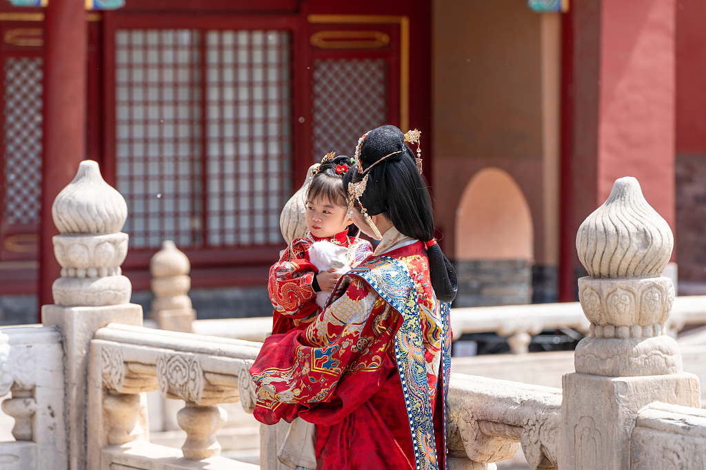 A mother and daughter dressed in traditional costume pose for a photo at the Palace Museum in Beijing, April 22, 2022. /CFP