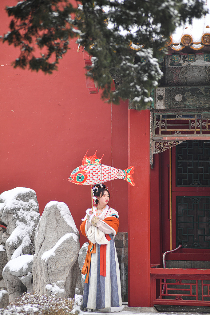 A costume-wearing visitor poses for a photo at the Palace Museum in Beijing, January 22, 2022. /CFP