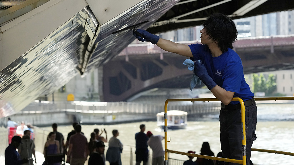 Ben Gallaido cleans the Chicago Riverwalk in Chicago, a day after heavy rains flooded Chicago streets and neighborhoods, July 3, 2023. /CFP