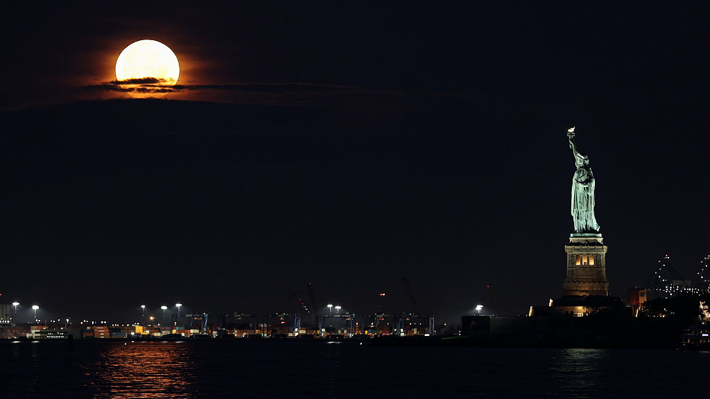 The July supermoon sets over the Statue of Liberty in New York City, U.S., July 3, 2023. /CFP