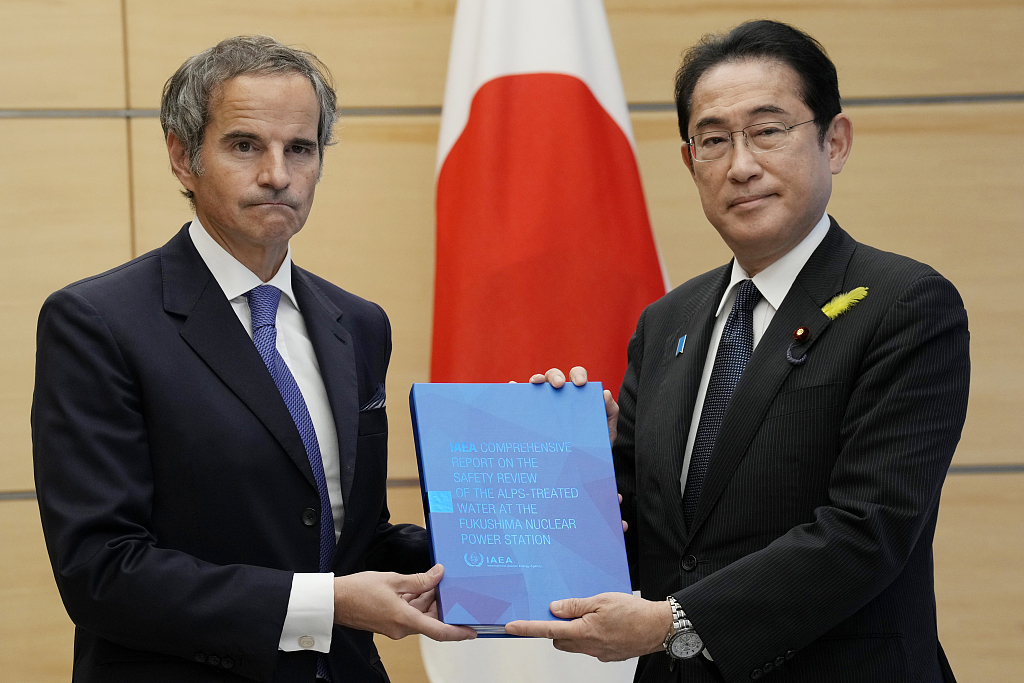 Rafael Mariano Grossi, director general of the International Atomic Energy Agency, left, presents IAEA's comprehensive report on Fukushima treated water release to Japanese Prime Minister Fumio Kishida at the prime minister's office in Tokyo, July 4, 2023. /CFP