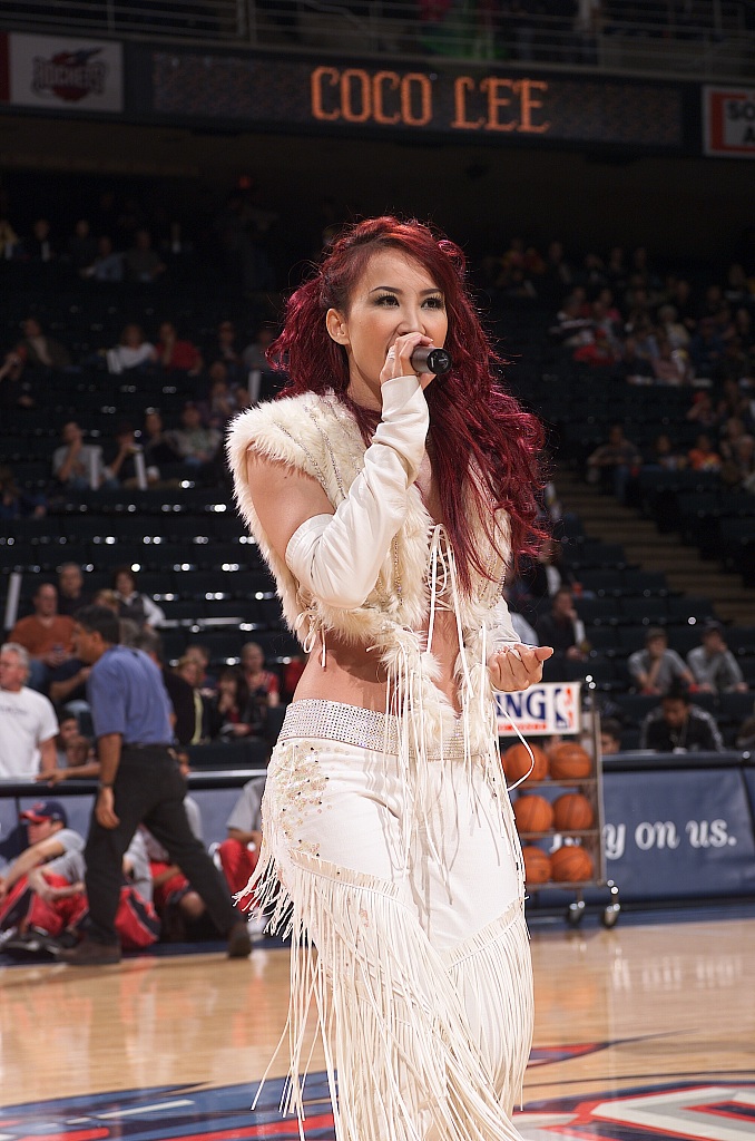 Coco Lee performs ahead of the NBA game between the Toronto Raptors and the Houston Rockets at the Compaq Center in Houston, Texas on November 2, 2002. /CFP