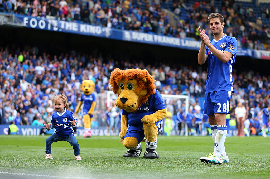 Cesar Azpilicueta with his daughter Martina and Chelsea mascot Stamford the lion after the Premier League match between Chelsea and Leicester City at Stamford Bridge in London, England, May 15, 2016. /CFP