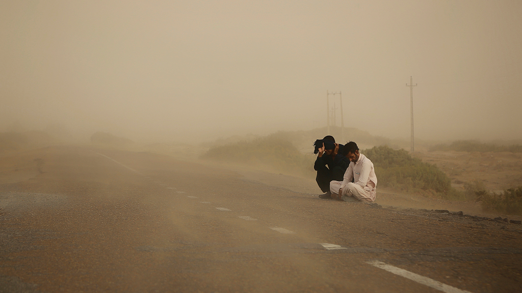 Two men sitting by the side of the road in the drought and water-scarred Iranian province of Sistan and Baluchistan, May 1, 2023. /CFP