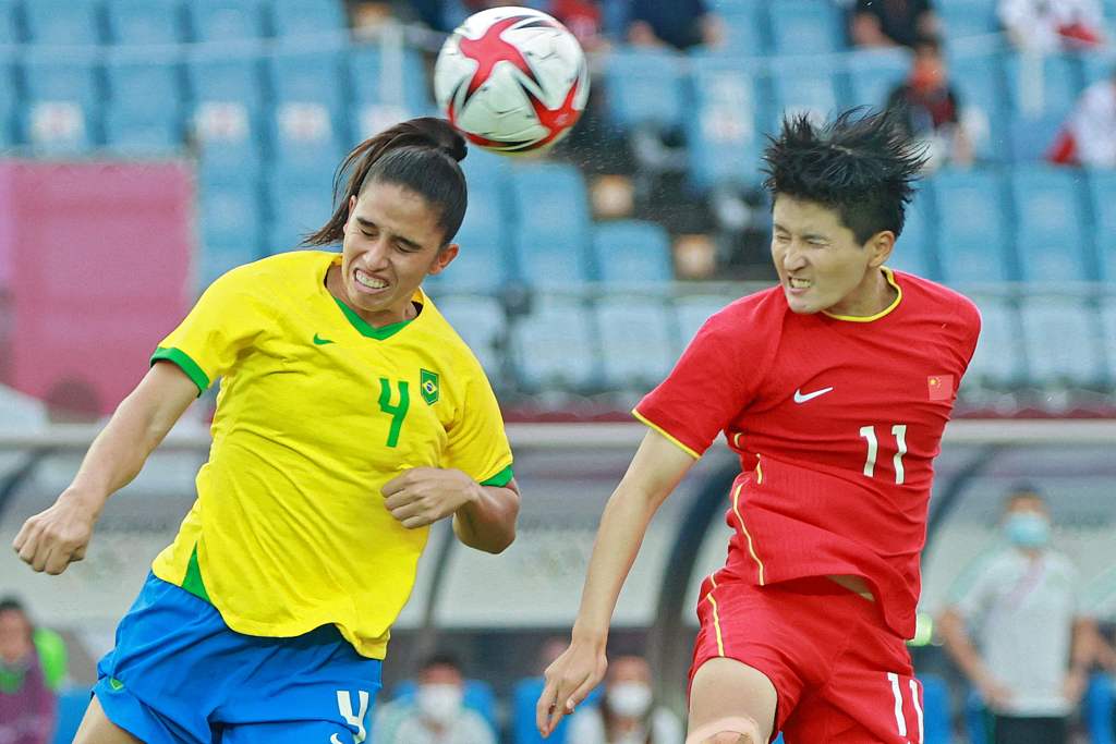 A brasileira Rafaelle (à esquerda) cabeceia com a atacante chinesa Wang Shanshan durante a partida de futebol da primeira rodada do Grupo F feminino dos Jogos Olímpicos de Tóquio 2020 entre China e Brasil no Estádio Miyagi em Miyagi em 21 de julho de 2021. /CFP