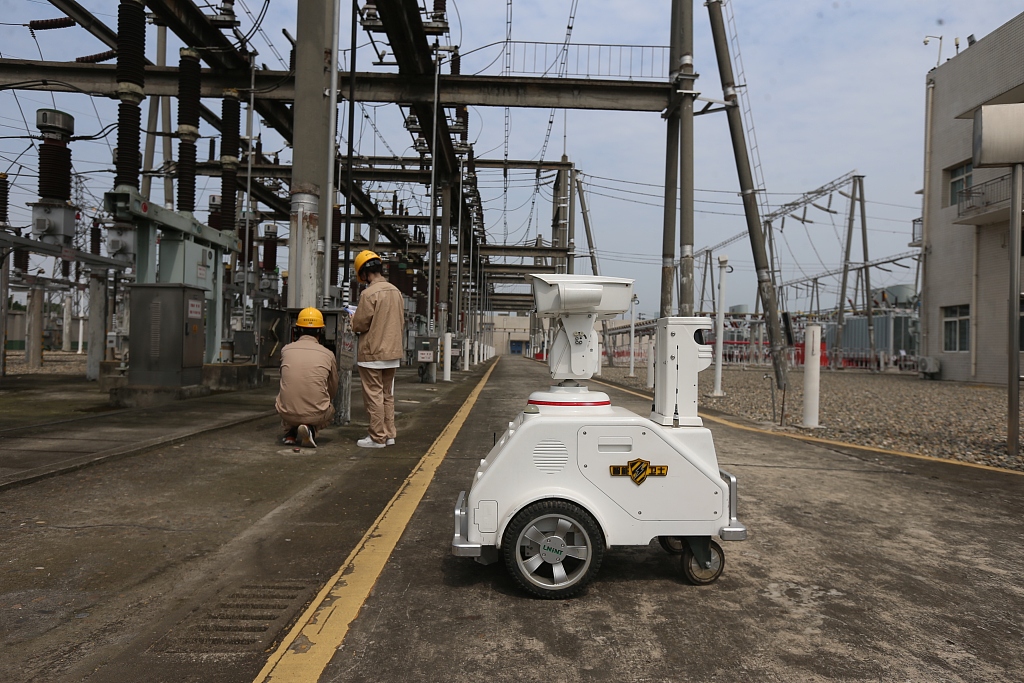 A 5G smart robot and operations engineers inspected the power supply equipment in Meishan, southwest China's Sichuan Province, July 6, 2023. /CFP