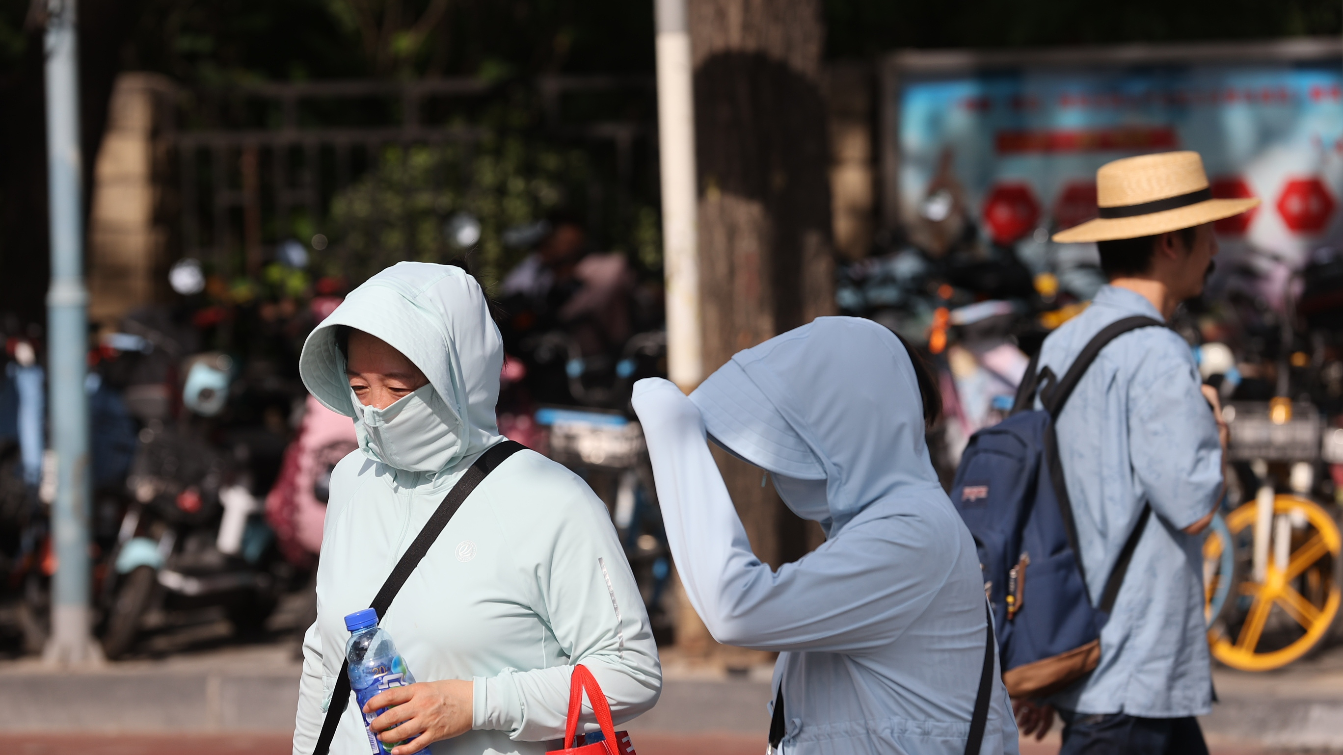 People wearing sun protection clothing take to the street in Sanlitun, Beijing, June 27, 2023. /CFP